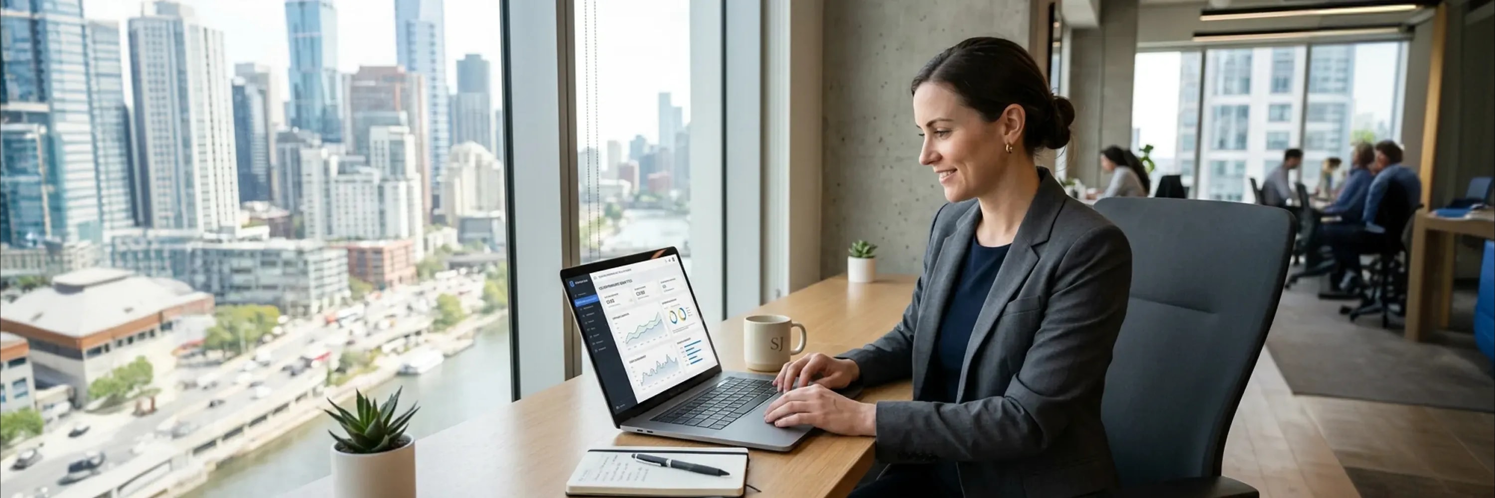 Business professional analyzing data on a laptop in a modern office with city skyline view and dashboard analytics on screen